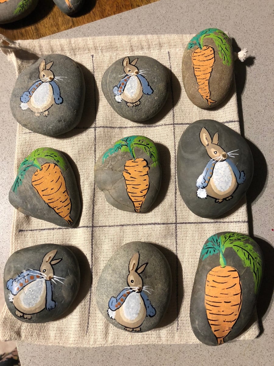 Easter-themed tic-tac-toe with painted rocks and a paper board