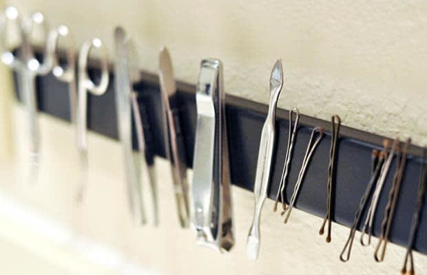 Declutter bathroom cabinets. Hang tweezers, nail clippers, and other bathroom utensils on a magnetic rack.